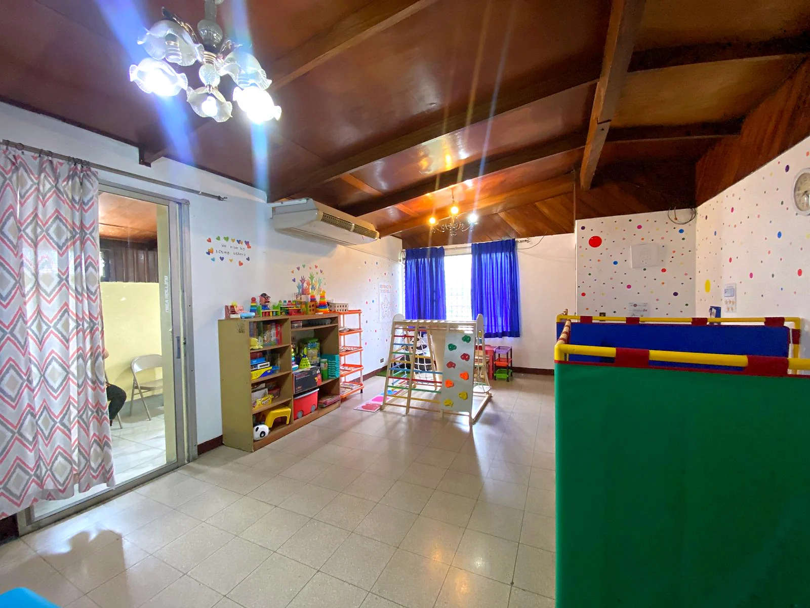 Sala terapéutica amplia con materiales infantiles y espacio de movimiento